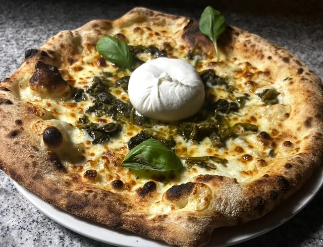 Pizza Friarielli mit Büffelmozarella Steinofenpizza mit geschmolzenem Mozzarella, frischem Basilikum und cremiger Burrata in der Mitte